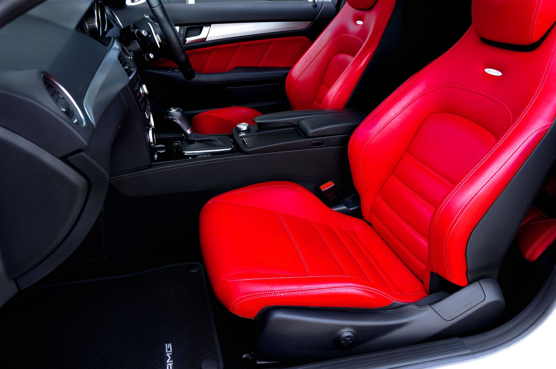 Elegant car interior featuring vibrant red leather seats and modern design.